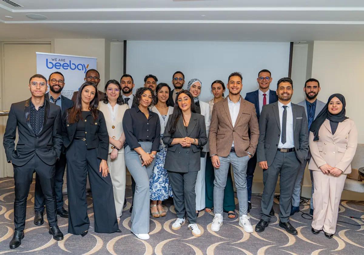 The We Are Beebay team in front of a company banner